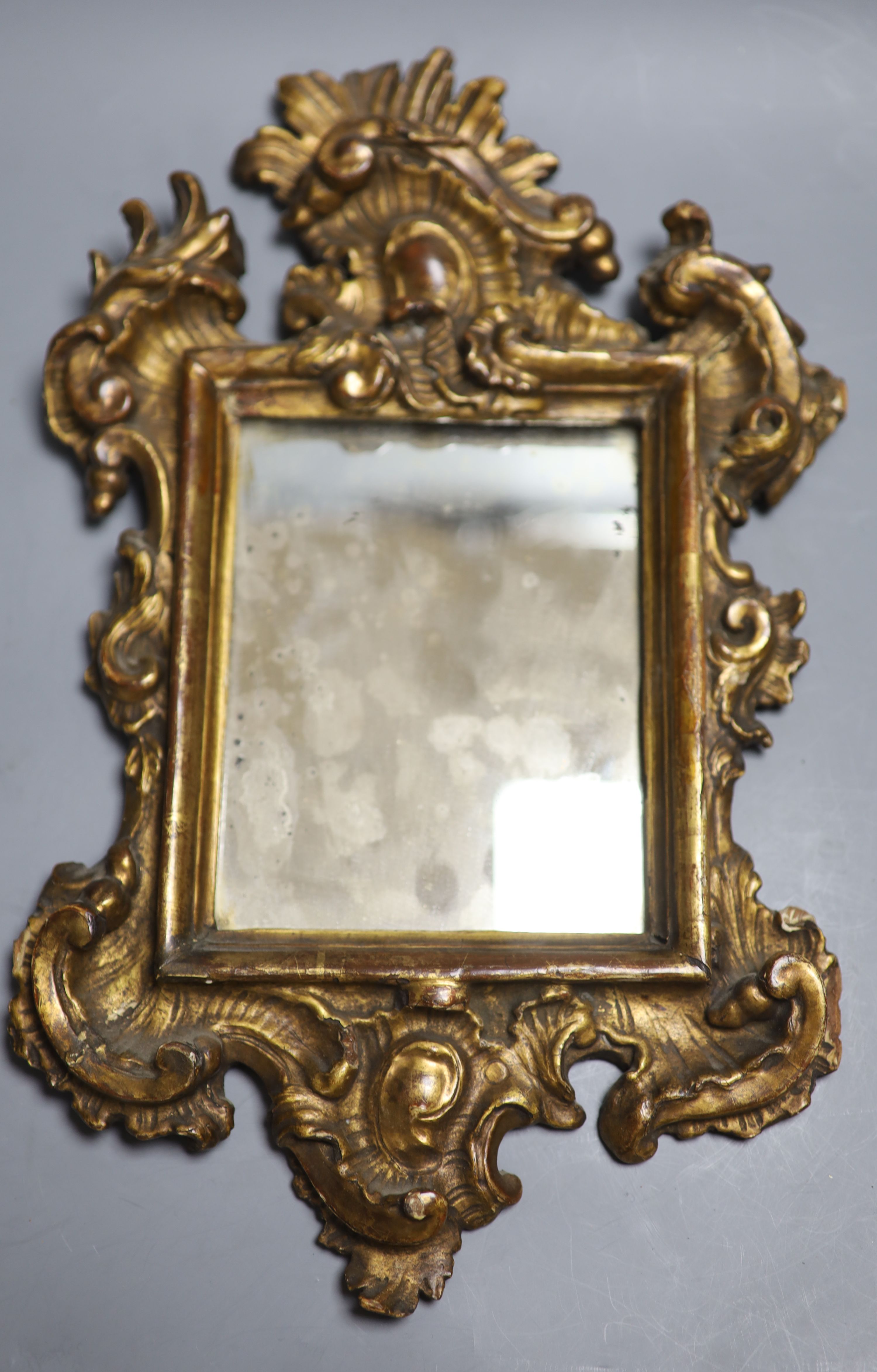 A small 18th century Italian carved giltwood mirror, overall length 38cm